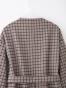 Close-up of the vintage red-brown plaid wool texture and back stitching on the long coat
