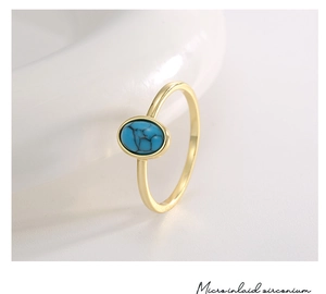 Macro detail of gold-plated bohemian ring featuring oval turquoise and micro-inlaid stones