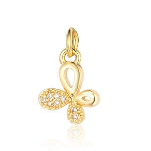 Detailed macro view of golden clover pendant with sparkling zircon stones and soft reflection
