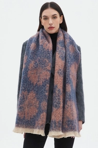 Close-up of floral jacquard pattern and beige fringe on blue and pink winter scarf