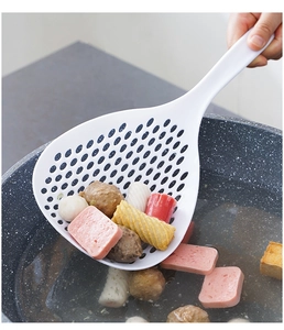 Action shot of white kitchen skimmer lifting hot food from a boiling cooking pot