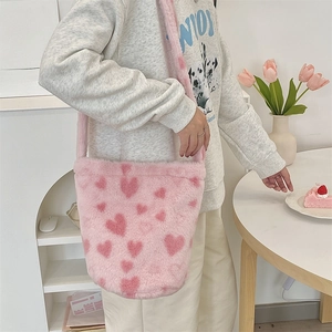 Detailed view of pink plush heart pattern bucket bag styled in a Korean aesthetic setting