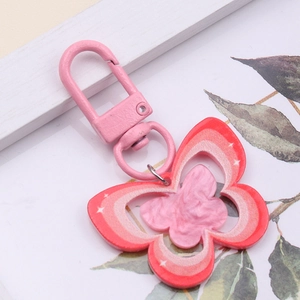Detailed macro view of pink butterfly acrylic keychain with white star patterns