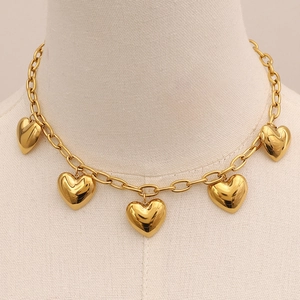Close-up of five 3D heart pendants on a gold chain displayed on a knit texture stand