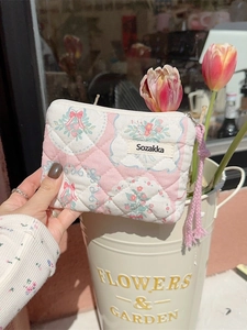 Floral quilted mini coin purse with pink bow pattern and braided zipper pull for travel