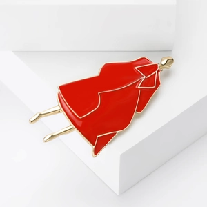 Fashionable enamel brooch of a woman in a red coat with gold trim on a white base