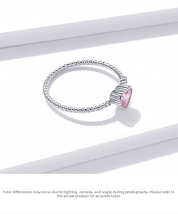 Macro shot of 925 silver twisted ring band with heart-shaped pink crystal gemstone