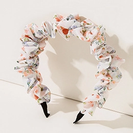 Detail of white fabric headband with blue and orange floral pattern and pleats