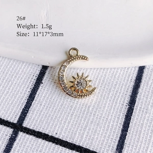 Macro detail of gold-plated moon and star charm pendant with clear crystal inlay