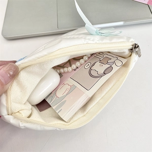 Quilted white cosmetic bag interior showing storage capacity for earphones and accessories