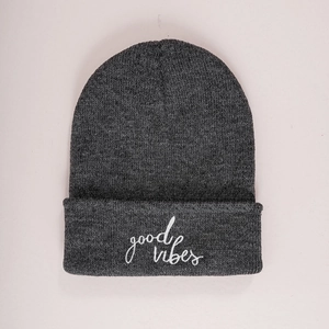 Detailed view of dark charcoal grey knit beanie featuring white good vibes embroidery