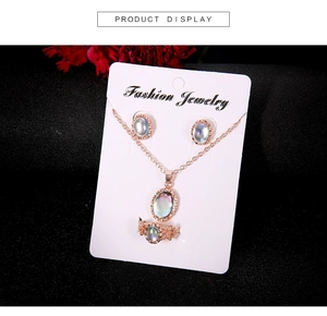 Detailed view of jewelry set with oval iridescent stones and rose gold finish on card