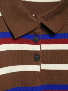 Detail of the knit polo shirt collar with horizontal stripes and two black buttons