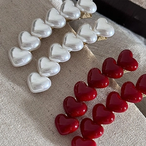 Elegant curved heart hair clips in pearl white and glossy red with metal duckbill base