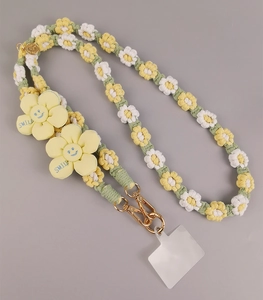 Detail of hand-woven daisy phone lanyard with yellow smile flowers and gold hooks