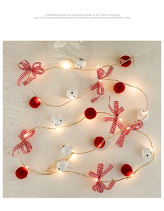 Detail of Christmas LED string lights with white star bells and red plush balls decorations