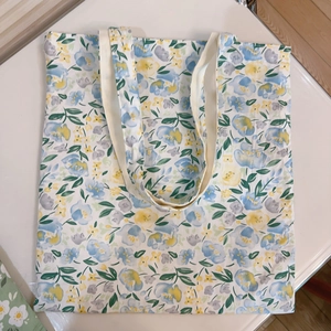 Detailed flat lay of floral canvas tote bag featuring fresh blue and yellow petal prints