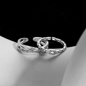 Detail of silver crossover twig rings with micro-pave cubic zirconia on black background