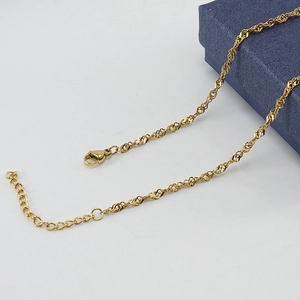 Detail of 18K gold stainless steel water wave chain with lobster clasp on jewelry box