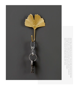 Detail of golden ginkgo leaf wall hook with intricate metal textures and key storage