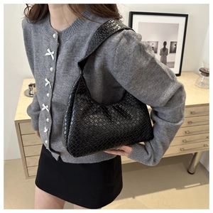 Close-up of black woven leather texture on a stylish women shoulder underarm bag