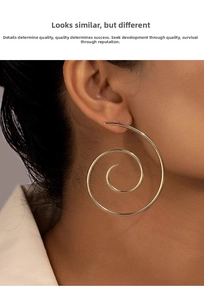 Close-up of a large golden spiral earring with artistic texture on a model's ear