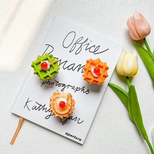 Macro view of cherry cream waffle phone grips on an open book with tulip flowers