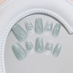 Handmade emerald green cat-eye press-on nails with silver bamboo texture patterns