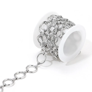 Close-up of DIY stainless steel geometric chain links wound on a white plastic spool