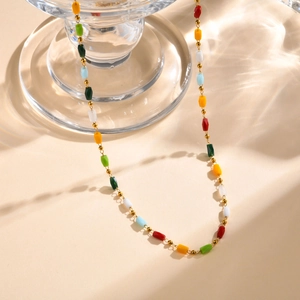 Dettaglio di collana di perle sfaccettate multicolori con distanziali dorati