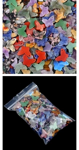 Macro shot of colorful stone butterfly pendants in packaging for jewelry DIY
