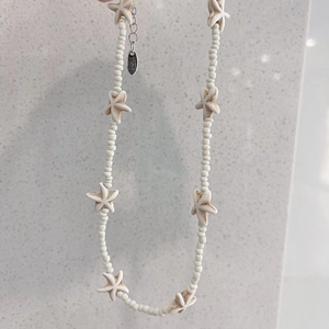 Close-up of handmade beaded necklace with starfish charms and adjustable silver clasp