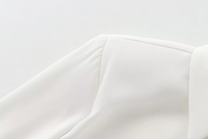 Close-up of shoulder pads and notch lapel on a white padded crepe long sleeve shirt