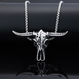 Pendentif tête de taureau argenté vintage avec chaîne maille box sur fond sombre