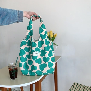 Close-up of cream corduroy tote bag with green heart patterns and LOVE SOZAKKA label