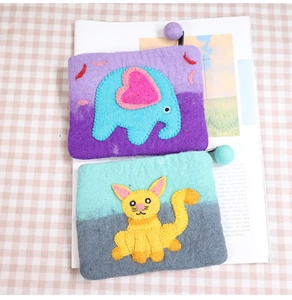 Detailed texture of handmade wool felt coin purses with elephant and cat animal designs