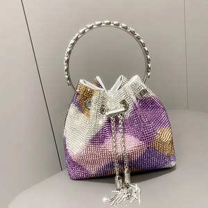 Dettaglio macro degli strass sfumati sulla borsa a secchiello con nappe luccicanti