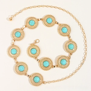Close-up of golden boho belt with turquoise stones and textured spiral metal discs