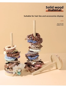 Detail of the solid wood hair tie organizer stand showing texture and usage