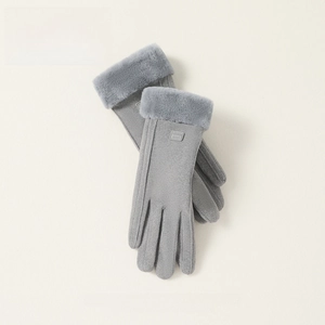 Close-up of grey suede gloves with thick faux fur cuffs and a fashion logo label