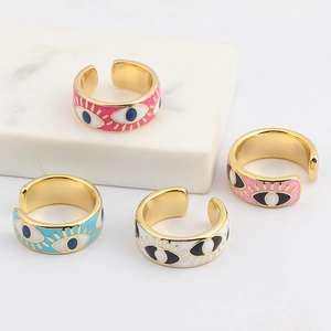 Detailed macro view of four colorful enamel evil eye adjustable rings on marble stones