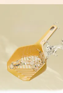 Close-up of bright yellow cat litter shovel with water splashes showing easy clean feature