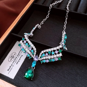 Macro shot of silver vintage necklace with colorful crystals and green pear pendant