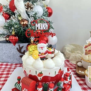 Close-up of Merry Christmas acrylic cake topper with Santa and Snowman figurines