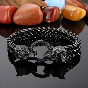 Detail of gunmetal wolf head link bracelet with intricate woven texture on dark stones