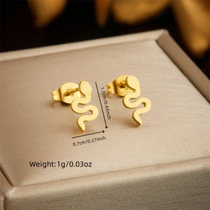 Macro shot of gold snake earrings on jewelry box showing size 1.1cm and textured metal finish