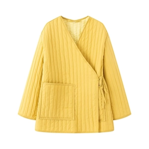 Detail of yellow quilted jacket with side ties and a large pocket on a white background