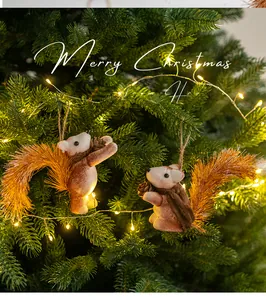 Détail de figurines d'écureuils en peluche avec queue touffue et pommes de pin sur un sapin