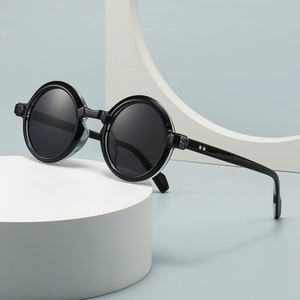Retro black round frame sunglasses displayed on minimalist light blue geometric props