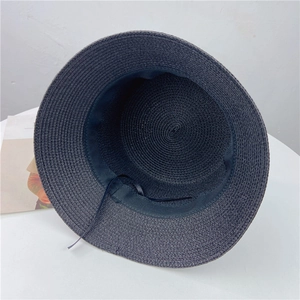 Detail view showing adjustable black inner strap and fine weave of straw sun hat